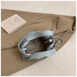 Top view of light blue bucket bag showing lychee grain leather and brown fabric lining