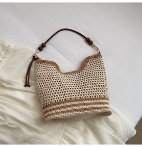 Detail of woven crochet tote bag with wooden bead strap and bohemian striped base