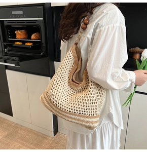Detail of straw woven tote with wood beads and gold metal hooks in a lifestyle setting