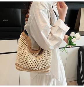 Detail of woven shoulder bag featuring brown stripes and decorative dark wooden beads