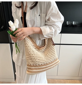 Detail of woven mesh pattern and brown leather strap on cream crochet tote bag