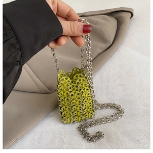 Detail of neon green metal disc woven mini bag with thick silver chain shoulder strap