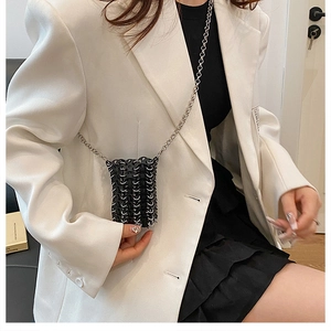 Mini black sequin chain bag styled with white blazer and pleated skirt