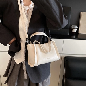 White pebbled leather basket bag with top handles and a detachable shoulder strap