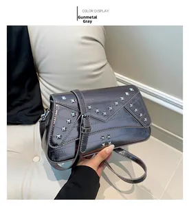 Detail view of gunmetal punk square bag featuring metallic studs and envelope flap