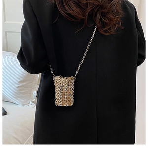 Detail of a handmade gold metal sequin woven mini crossbody bag with a slim chain strap