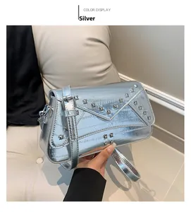 Detail of silver metallic crossbody bag with square rivets and adjustable strap