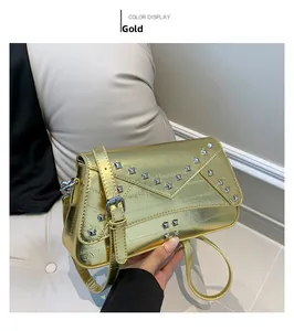 Detail view of gold metallic square bag featuring silver pyramid studs and flap closure