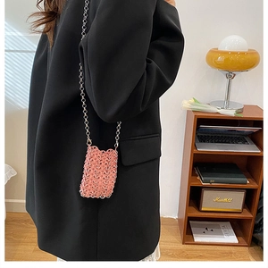 Detail of pink metal woven mini bag with unique honeycomb texture and silver chain strap