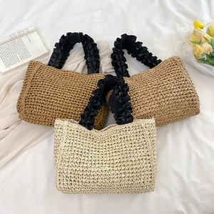 Handmade woven straw tote bags with pleated black ribbon handles for beach vacations