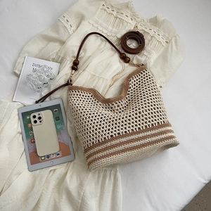 Woven crochet tote bag with brown stripes and leather straps for summer beach travel