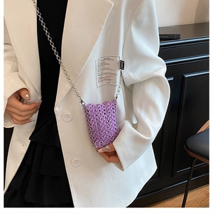 Chic purple mini crossbody bag with woven metal rings and delicate chain strap worn by model
