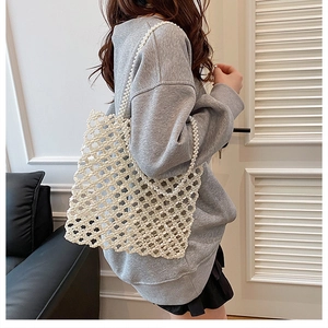 Détail du sac cabas blanc perlé avec son tressage ajouré et sa longue bandoulière
