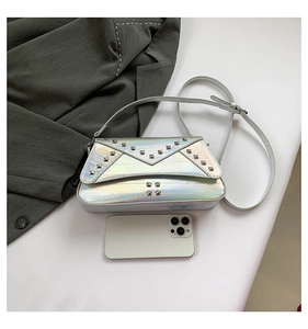 Detail of silver metallic rivet bag with phone for size reference on grey suit