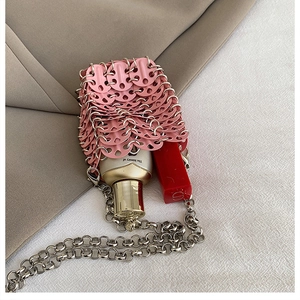 Detailed view of mini pink sequin bag with silver chain holding lipstick and skincare