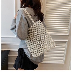 Vue d'épaule du sac fourre-tout perlé fait main avec structure en maille tissée