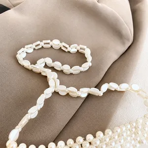 Detailopname van de elegante witte ovale faux parel schouderriem met parelmoerglans