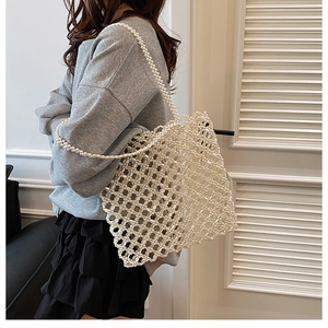 Modèle portant un sac cabas en perles fait main blanc avec motif tissé en maille