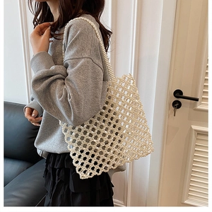 Vue détaillée d'un sac cabas tissé en perles blanches porté par un mannequin en intérieur