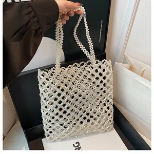 Détail du sac cabas en perles blanches tressées montrant l'artisanat du filet ajouré