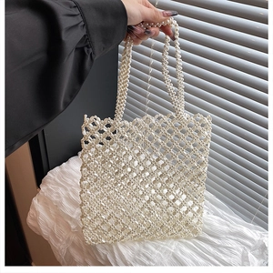 Détail d'un sac cabas en perles blanches tressées avec un motif de maille ajourée