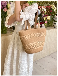 Close-up of hand-woven straw tote bag with horizontal wavy texture and natural finish