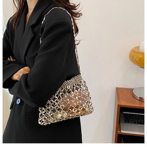 Detail van zilveren metallic mesh schoudertas met schakels en ketting op zwarte blazer