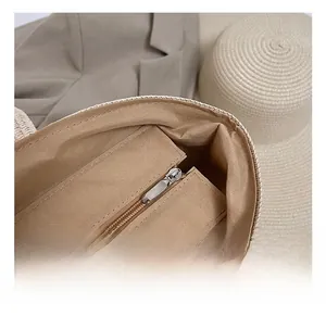 Detail shot of the interior lining and metal zipper pocket of the straw tote bag