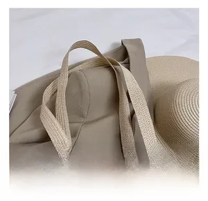 Detail of woven straw tote bag handles showing natural fiber texture and beige finish