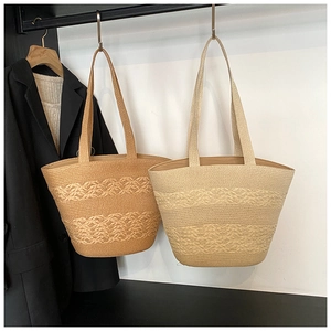 Close-up of textured straw tote bags in beige and khaki with woven wave patterns