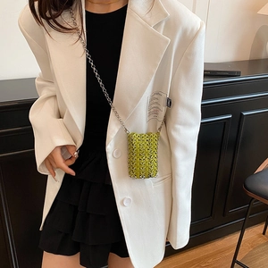 Neon green woven metal mesh mini crossbody bag with silver chain strap on white blazer