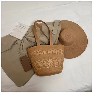 Detailed view of woven straw tote bag with delicate wave hollow patterns and natural texture