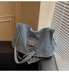 Detail of blue denim tote bag showing vintage texture and silver metal buckle