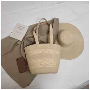 Flat lay of beige straw tote bag showing hollow-out weave pattern and woven handles