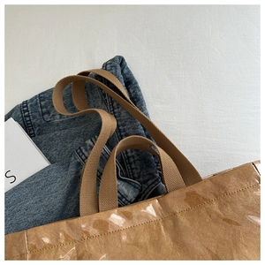 Macro detail of brown crinkled tote bag texture with durable woven handle straps