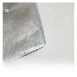 Macro detail of silver Tyvek tote bag featuring metallic texture and white G logo