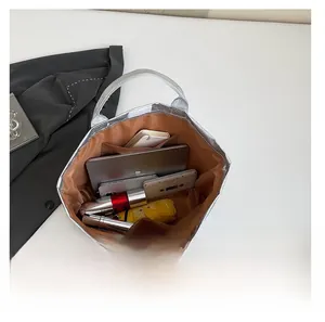 Top view of large silver tote bag interior showing capacity for laptop and daily items
