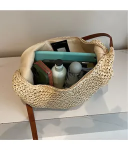 Top view of spacious interior of woven straw bag with leather straps for daily items