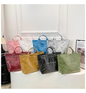 Huit sacs cabas en PVC colorés disposés sur un support d'exposition blanc minimaliste