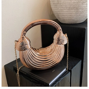 Macro shot of rose gold acrylic evening bag with wave texture and round metal handle