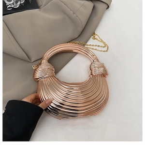 Detailed view of gold acrylic evening clutch with textured stripes and metal chain strap