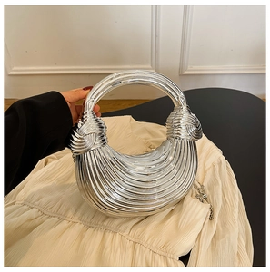 Detailed view of silver acrylic clutch bag with pleated texture and round handle