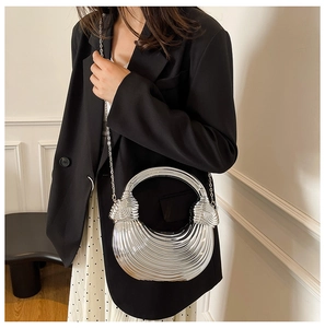 Detail of silver metallic semi-moon handbag with textured stripes and chain strap