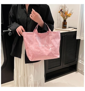 Détail du sac cabas rose en Tyvek avec couche PVC transparente et texte TOTE BAG moderne