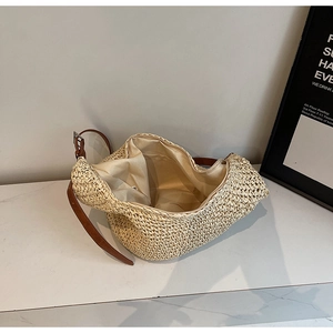 Detail of woven straw hobo bag showing spacious interior, fabric lining and zipper closure