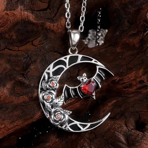Gothic crescent moon necklace with silver roses, bat pendant, and red heart gemstone