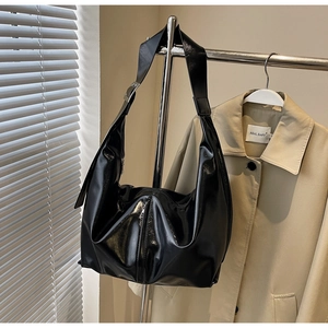 Détail d'un grand sac fourre-tout en cuir verni noir brillant avec boucle en argent