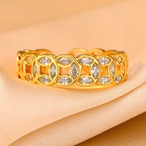 Close-up of gold coin ring with marquise-cut zircons on champagne satin background