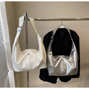 Détail de sacs hobo minimalistes blanc et argent avec larges bandoulières et zips