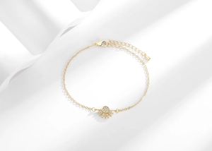 Detail of gold sun pendant with cubic zirconia on adjustable chain bracelet